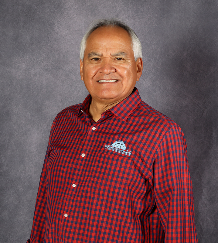Luis smiling and wearing a red checker shirt