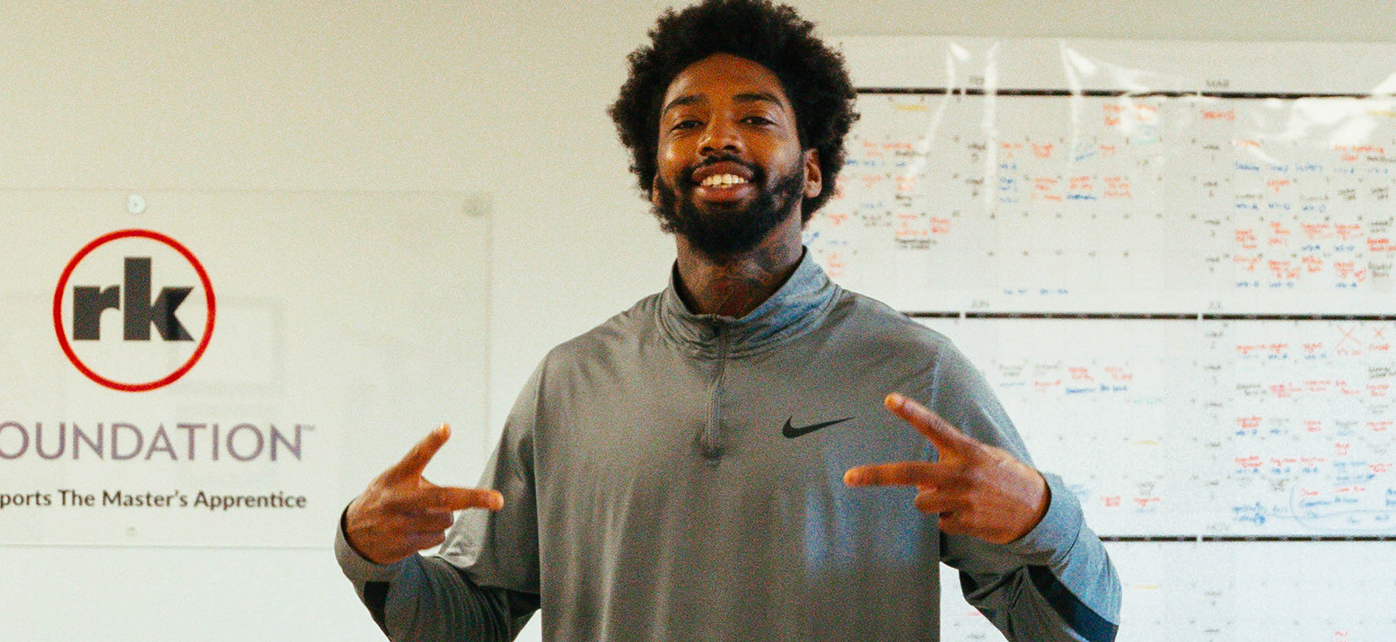 A man smiling and holding up peace signs