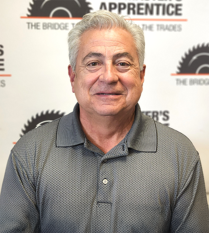 Scott in front of a back drop with Masters Apprentice logos