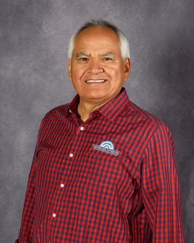 Luis smiling and wearing a red checker shirt