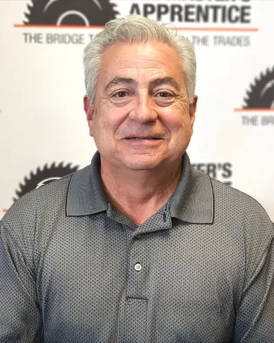 Scott in front of a back drop with Masters Apprentice logos